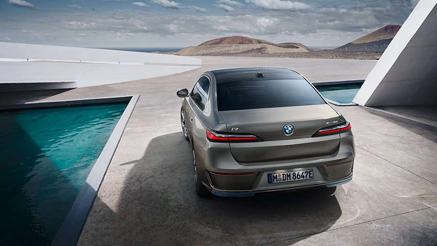 BMW i7 von hinten vor Bergkulisse.